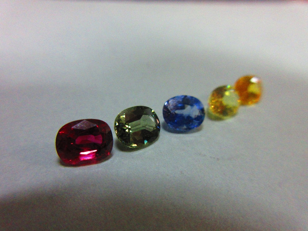 A loose ruby and four loose variously coloured sapphires, all oval to rectangular cushion cut and - Image 4 of 5