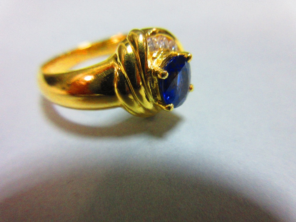 A modern asymmetrical 18ct gold and gemset ring, with a central claw set oval cut vivid blue - Image 4 of 5