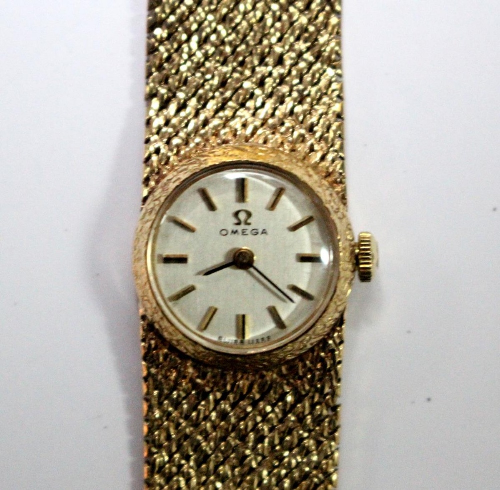 By Omega - a lady's 9ct gold cased wristwatch, the round silvered dial with baton numerals,