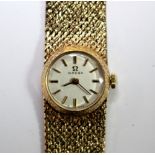 By Omega - a lady's 9ct gold cased wristwatch, the round silvered dial with baton numerals,