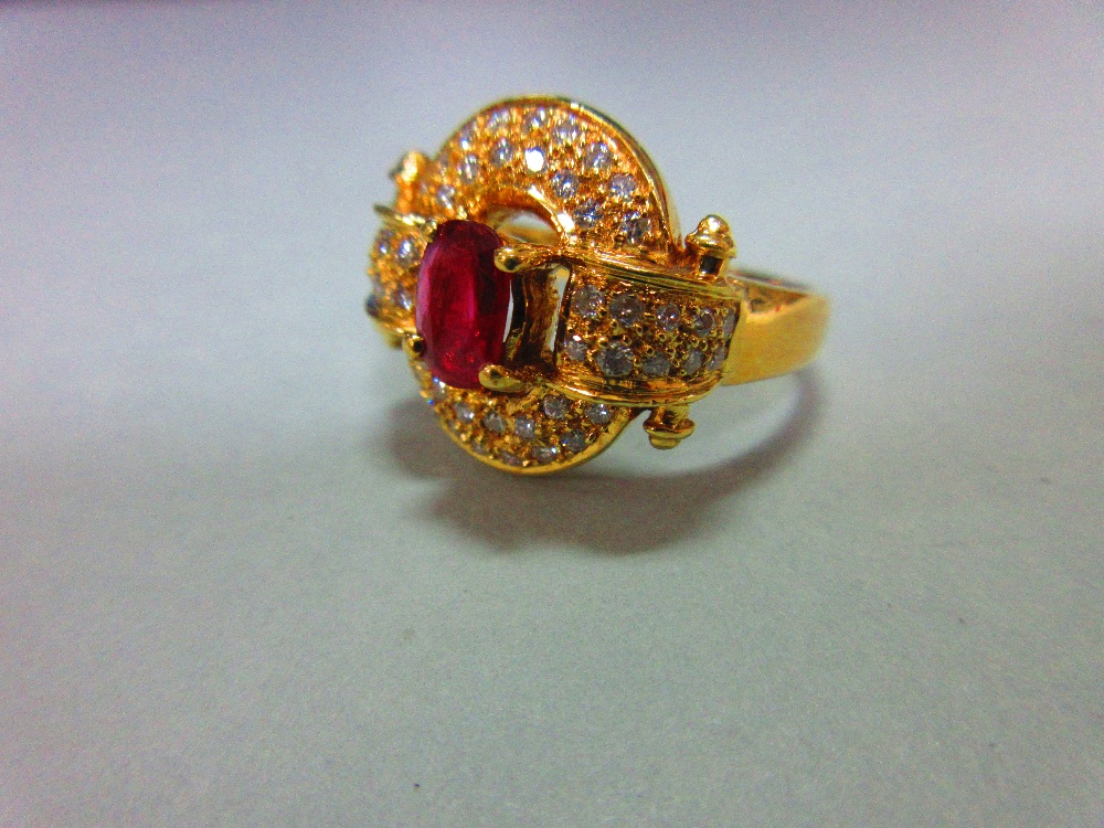 A red hardstone and diamond cluster ring, the oval cut red stone, believed to be a ruby, but not - Image 2 of 5