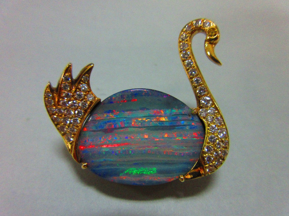 An opal and diamond brooch in the form of a swan, the body of the swimming bird formed by an ovoid