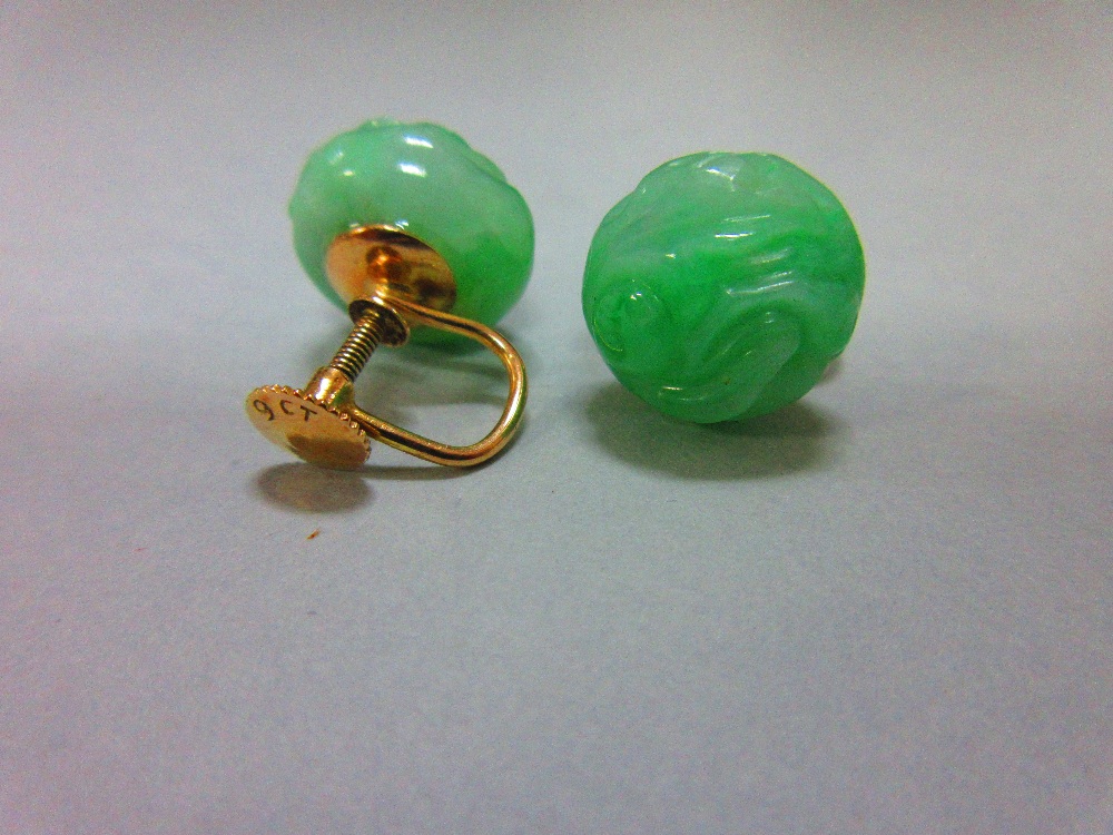 A pair of carved jadeite jade screwback earrings, each bouton of light emerald green mottled jade - Image 3 of 3