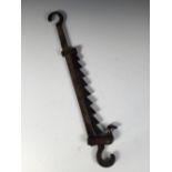 A late 18th/early 19th century brass adjustable pot hook, opposing hooks at each end, the saw