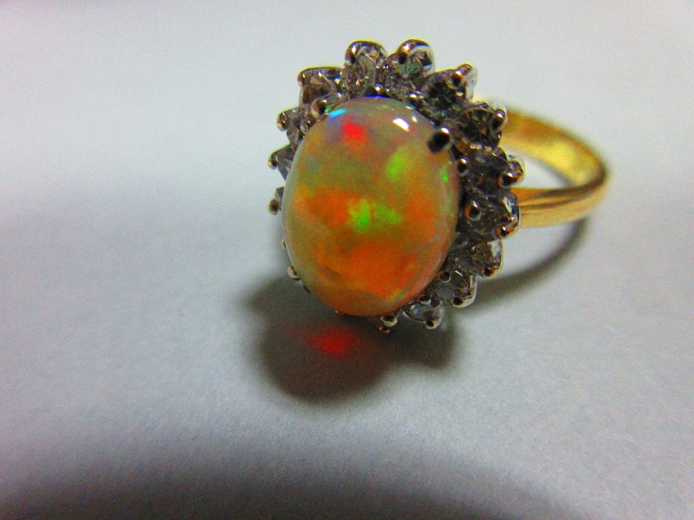 An opal and diamond cluster ring, the oval cabochon opal, displaying vivid predominently green and - Image 3 of 6