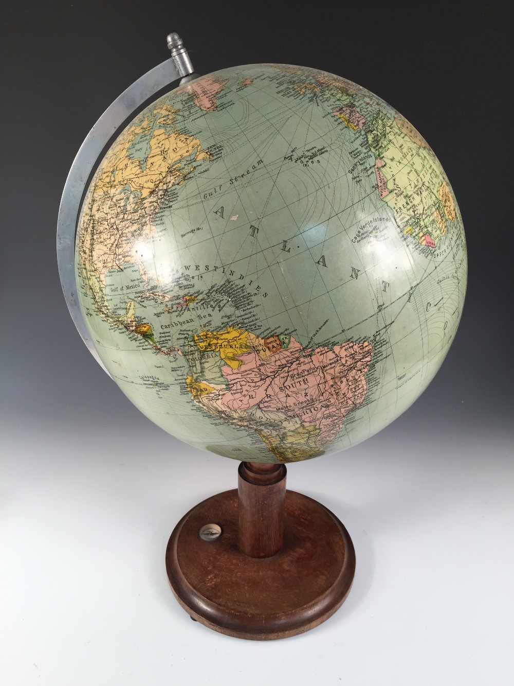 A 1930's terrestrial 12 inch table globe, mounted on a turned wooden base with inset compass 53cm (