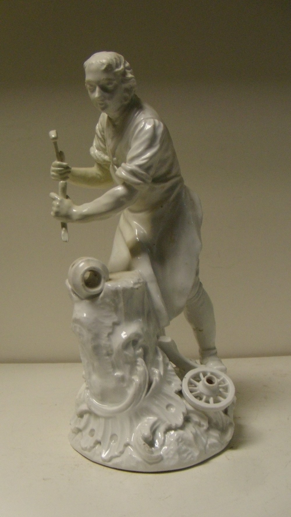 After Kaendler and Reinicke, an 18th century Meissen white glazed figure of a wheelwright, he stands