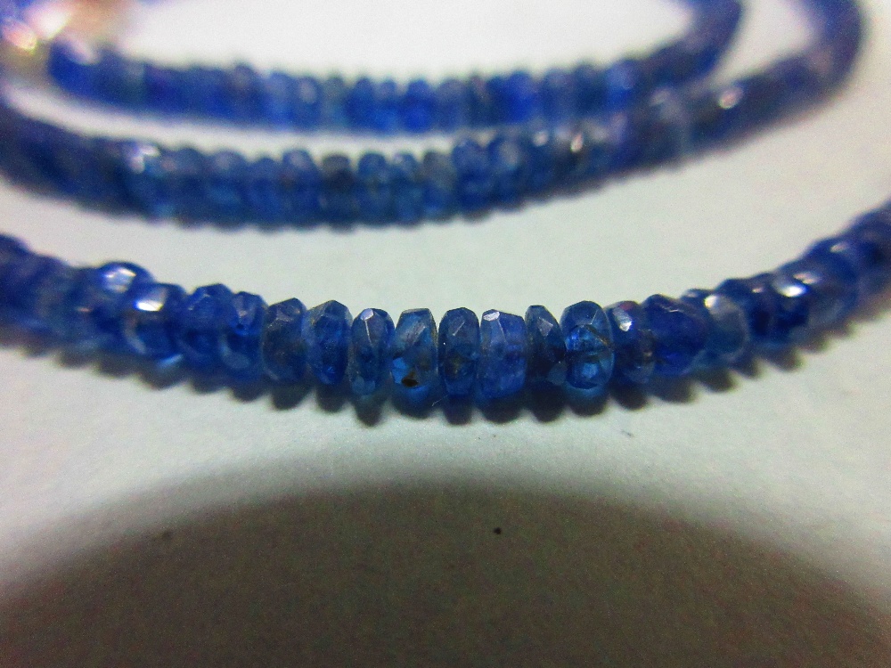 A sapphire bead necklace, the uniform 3mm diameter faceted sapphire beads of dusky mid blue, closely - Image 2 of 3