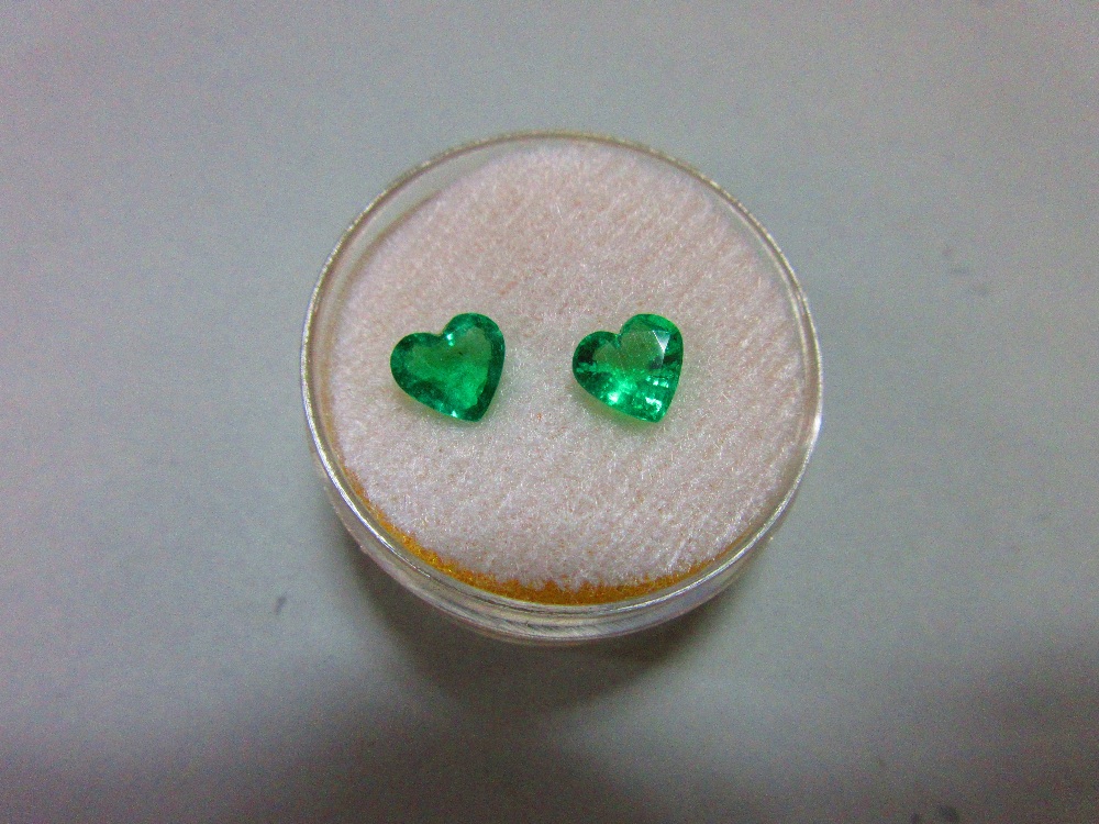 A pair of loose heart cut emeralds, the well-matched stones, suitable for earrings, of bright