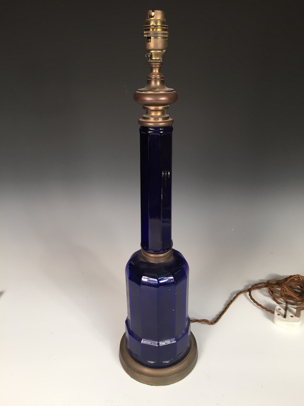 A Victorian blue glass table lamp, the octagonal column above a broad base and brass mounts,