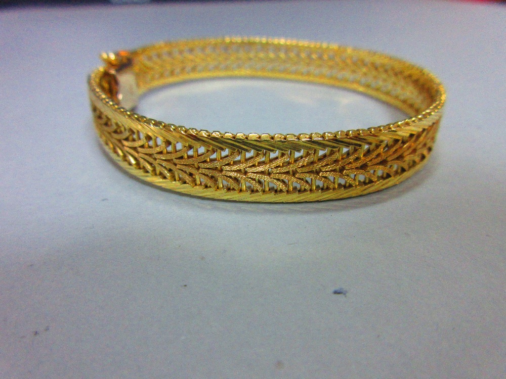 An Austrian 14ct gold bracelet, the delicate pierced polished and textured ribbon band, width 1cm,