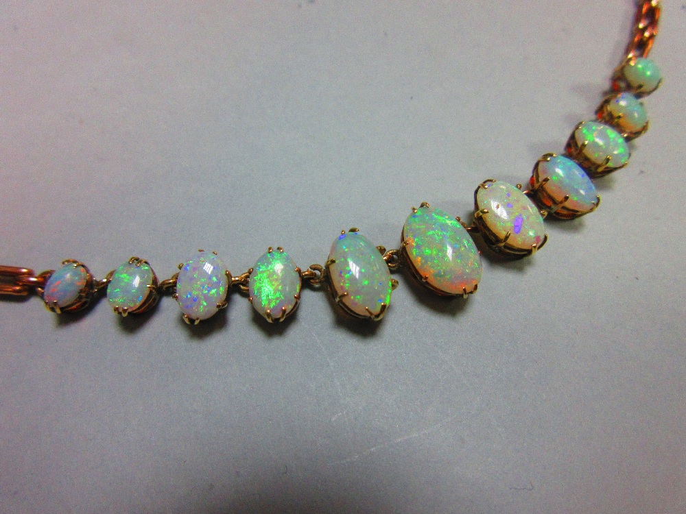 A graduated opal necklace, set to the front with an articulated line of eleven oval cabochon opals - Image 2 of 6