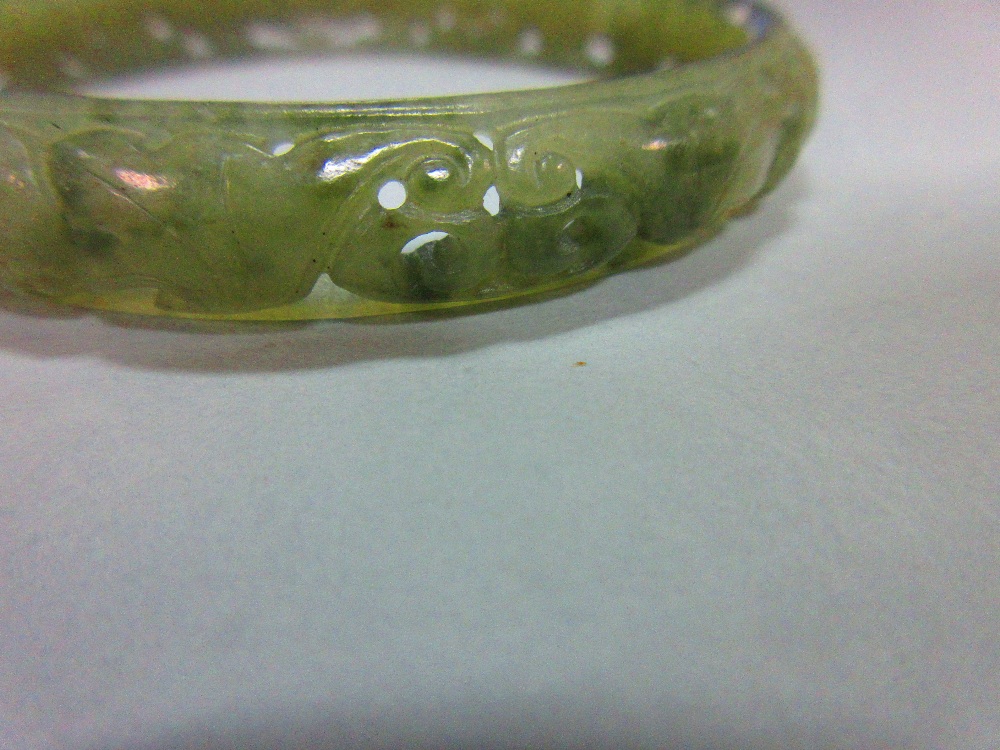 A carved jade bangle, the mottled light green jade of convex profile, pierced and carved with - Image 5 of 5
