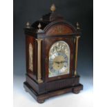 An imposing Victorian rosewood and brass inlaid chiming clock, the breakarch case with brass