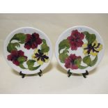 A pair of Moorcroft Hibiscus pattern plates with white ground and yellow and pink flowers, each 31cm