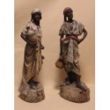 A pair of early 20th century Continental plaster Blackamoor figures of water carriers, tallest