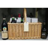 A wicker bottle basket with twelve compartments, and containing olive oil (4 bottles), sherry etc.