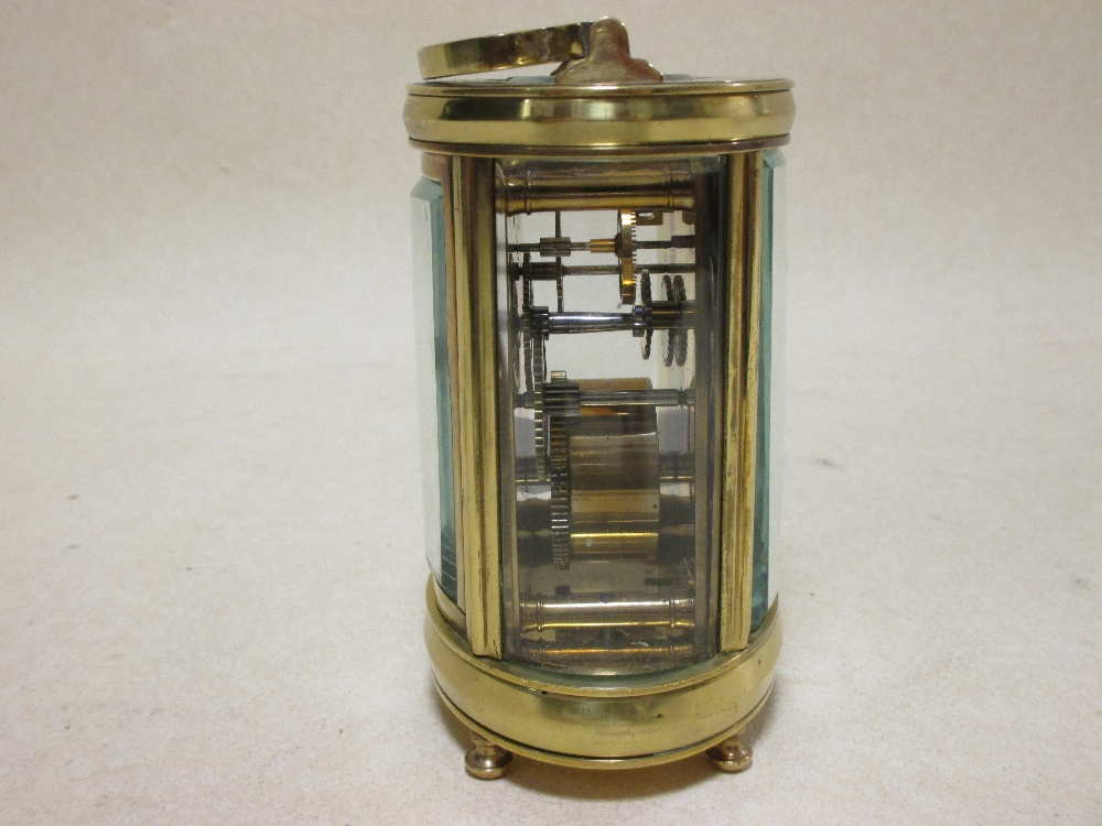 An early 20th century brass carriage clock, the oval body with glass panels, 12cm high handle down - Image 2 of 3