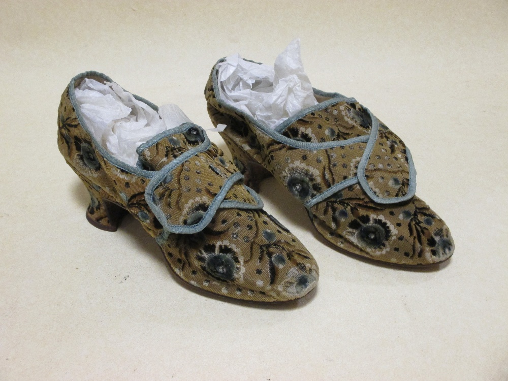 A pair of late 17th century ladies silk slippers, the late ground with blue borders and flowers