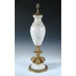 A gilt brass mounted alabaster table lamp, the baluster form raised on four dolphin base and stepped