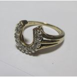 A diamond set horseshoe ring, set to trifurcated shoulders and tapering band, stamped 9ct and 375,