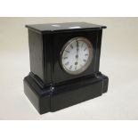 A black marble mantel clock, an oak tantalus, and a suitcase