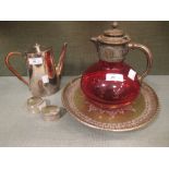 A cranberry glass claret with metal mount and handle together with a plated coffee pot, two napkin