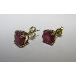 A pair of ruby earstuds, the round rubies, approx. 7.7mm diameter, in a four claw setting with ear