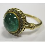 An emerald and diamond cluster ring, the round emerald cabouchon, approx. 9.8mm diameter, collet set