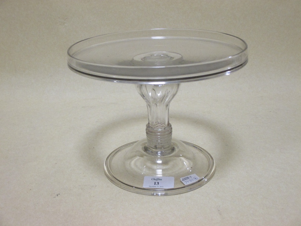 A 19th century glass comport, with a dished top, a shaped ring column and stepped foot, 21cm