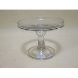 A 19th century glass comport, with a dished top, a shaped ring column and stepped foot, 21cm