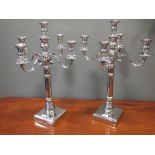 A pair of nickel plated five branch candleabra, on square bases