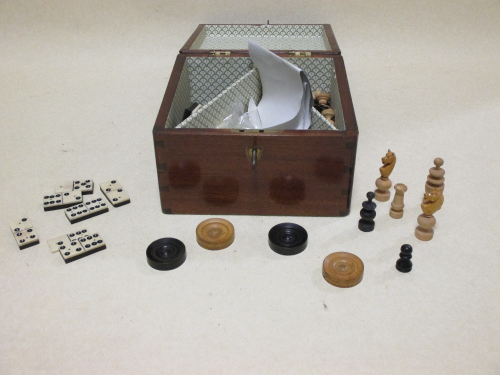 A mahogany box containing chess playing pieces