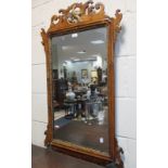 A George III style mahogany fret carved parcel gilt wall mirror, decorated with a bird, 105 x