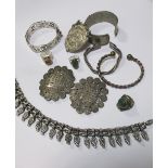 A group of white metal jewellery to include a fringe necklace, a Chinese belt buckle, a Mexican