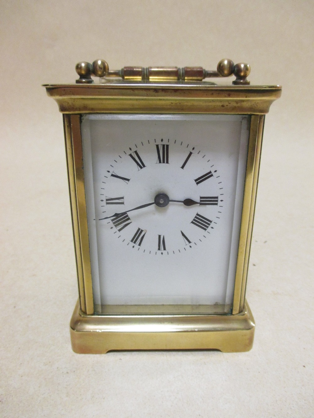 A brass cased carriage clock with white dial and black Roman numerals, 11.5cm high handle down