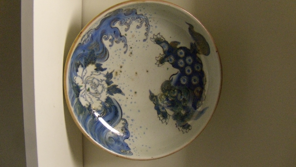 A 19th century Japanese Arita shallow bowl painted in blue and gilt with a shishi, seal mark of