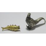 A silver model of a pheasant, London 1973, 7cm long and an articulated 9ct gold fish charm (7g) (2)