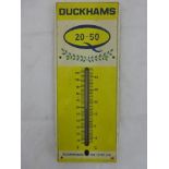 A Duckhams 20-50 tin fronted and plastic wall thermometer of unusual small size, 5 1/2 x 13".