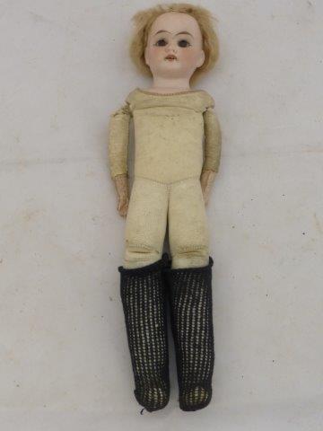 A small bisque headed doll with leather padded body and glass eyes.