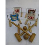 A child's table top croquet set with two balls and two mallets.