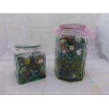 Two jars of assorted marbles, various sizes and ages.