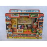 A 'Modern Sweet Store' toy shop display with assorted packaging and early advertising items.