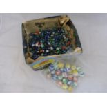 A large tin of assorted marbles.