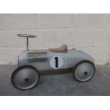A tinplate pedal car in the form of a single seater racing car.