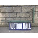 A rare double-sided enamel sign on original iron bracket - 'Auction Hall', 24 1/4 x 9".