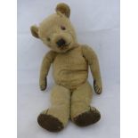 An early 20th Century jointed teddy bear.