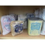 A collection of flour and sugar bags and a McDougall's Flour square tin.