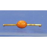 A Bar Brooch in 9ct yellow gold, the centre set with a cabochon oval opal of coral/orange and green,