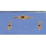 A 9k Bar Brooch set with scrolled openwork with garnet centre together with a pair of matching